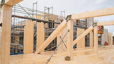 Foto der Uni Witten von außen. Man sieht die Montage der Brettschichtholzträger und Holzelemente.