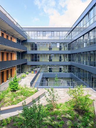 Exterior view of a schoolyard with plants and seating