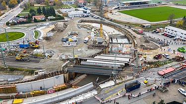 Aerial view of a construction site with railroad line and underpass