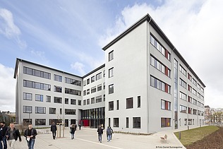 Eingangsbereich des Schulhofs mit moderner Architektur und barrierefreiem Zugang