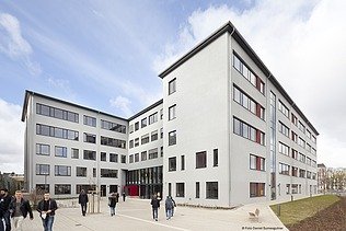 Eingangsbereich des Schulhofs mit moderner Architektur und barrierefreiem Zugang