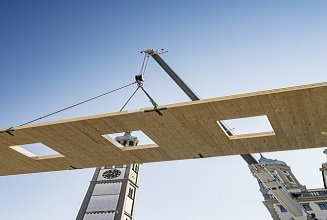 Photo of cross laminated timber element on crane for Fuggerei Pavilion Augsburg