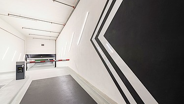 Photo of a driveway with barrier system in an underground parking garage