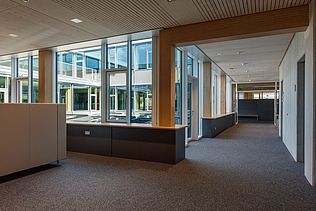 Innenaufnahme des Paul-Klee-Gymnasiums in Gersthofen. Man sieht eine Holz-Pfosten-Riegel-Fensterfassade.