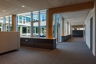 Innenaufnahme des Paul-Klee-Gymnasiums in Gersthofen. Man sieht eine Holz-Pfosten-Riegel-Fensterfassade.
