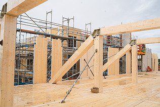 Foto der Uni Witten von außen. Man sieht die Montage der Brettschichtholzträger und Holzelemente.