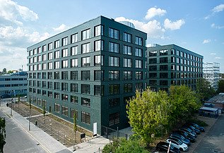 Exterior view of the INK Inspire Neukölln in Berlin with striking green façade