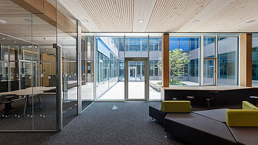 Innenaufnahme des Paul-Klee-Gymnasiums in Gersthofen. Man sieht eine Holz-Pfosten-Riegel-Fensterfassade.