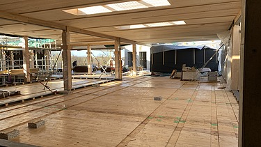 Foto des Rohbaus des Paul-Klee-Gymnasium in Gersthofen. Man sieht viele Holzoberflächen im Innenraum.