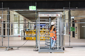 Picture of an access control point showing a woman just passing through the turnstile