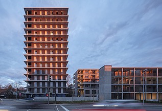 Außenansicht auf das Holzhochhaus CARL am Abend bei Sonnenuntergang