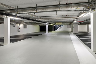Photo of an underground parking garage with parking spaces in black color