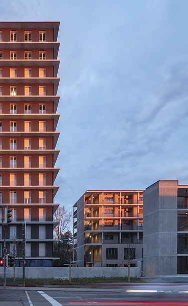 Exterior view of the CARL wooden high-rise in the evening at sunset