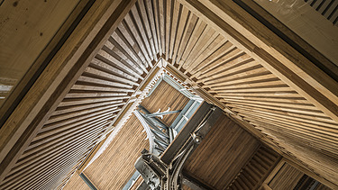 Foto im inneren der Halle von Gare Maritime Brüssel. Blick nach oben zur Deckenkonstruktion aus Holz.