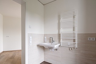 Example bathroom in the HUGO Komfort residential complex in Bayreuth with light-colored tiles