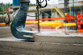 Photo of the print head of a 3D concrete printing machine creating a wall