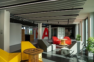 Das Innovation Center in Stuttgart, Sicht auf einen Open Space mit bunten Stühlen
