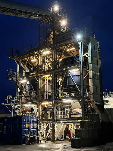 The floor washing tower is brightly lit in the evening.