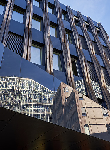 Außenansicht der Fassade eines der Firmengebäude von ZÜBLIN. In der Fassade spiegelt sich ein weiteres Gebäude