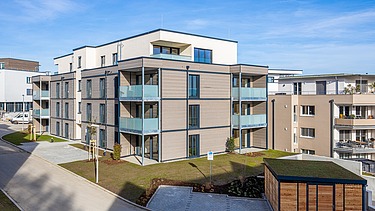 Außenansicht eines der beiden Wohngebäude mit einer Fassade aus Holz und Putz