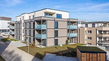 Außenansicht eines der beiden Wohngebäude mit einer Fassade aus Holz und Putz