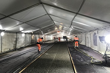 Foto von Personen mit Warnweste in einem Zelt