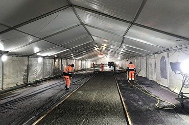 Photo of people with high-visibility vests in a tent