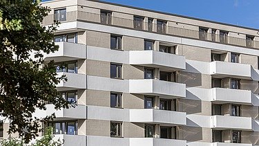 Aufnahme der Wohnanlage Atriumquartiers in Leipzig, mit hellbrauner Fassade und weißen Balkonen