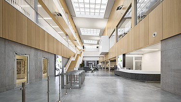 Foto eines großen Innenraumes mit vielen Beton- und Holzoberflächen.