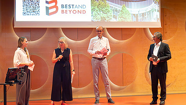 Company colleagues and the moderator at the stage of the symposium