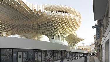 Foto des Marktplatzes mit Einkaufsarea in Sevilla Spanien. Man sieht pilzartige Holzkonstruktionen.