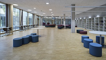 Spacious lounge with blue seating and a window front