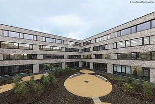 Green schoolyard with surrounding buildings