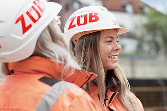 Picture of two women on the construction site wearing ZÜBLIN helmets