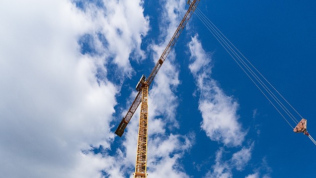 A photograph of a large crane with a jib that seems to reach up into the sky