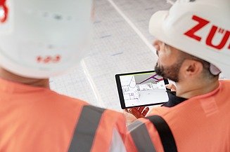 Bild von einem Bauarbeiter mit Tablet auf der Baustelle