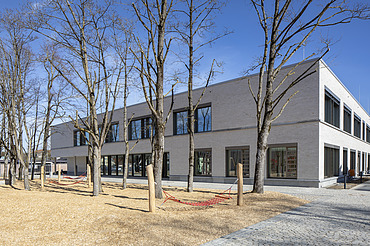 Außenaufnahme der Vinzenz-Pallotti-Schule in Friedberg. Man sieht ein großes, weißes Gebäude mit Flachdach.