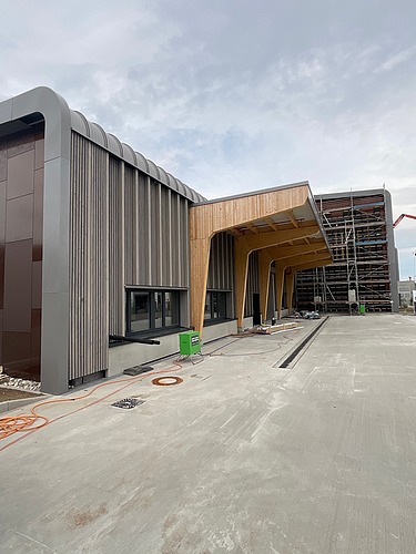 Foto der Baustelle Erbe in Rangendingen. Man sieht große Brettschichtholzträger am Eingangsbereich.
