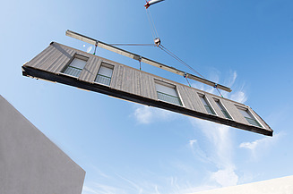 Photo of prefabricated LENO-ADD exterior wall element for assembly on the crane