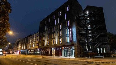 Night view of the PREMIER INN Hamburg-St. Pauli hotel with illuminated façade