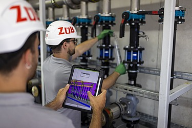 Bild von zwei Arbeitern der Umwelttechnik die eine Wasserprobe entnehmen