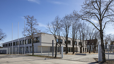 Außenaufnahme der Vinzenz-Pallotti-Schule in Friedberg. Man sieht ein großes, weißes Gebäude mit Flachdach.