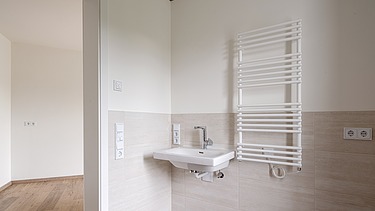 Example bathroom in the HUGO Komfort residential complex in Bayreuth with light-colored tiles