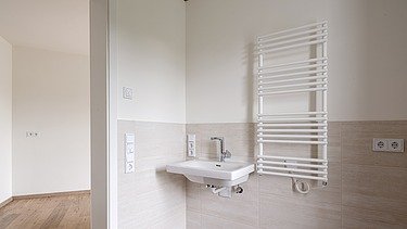 Example bathroom in the HUGO Komfort residential complex in Bayreuth with light-colored tiles