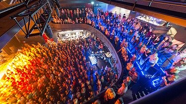 Concert hall of the multifunctional building filled with people and subdued lighting