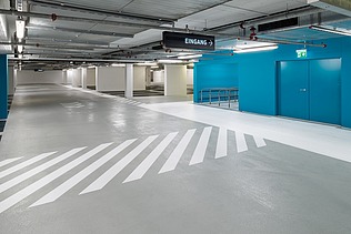 Photo of an underground parking garage with white-blue color accents