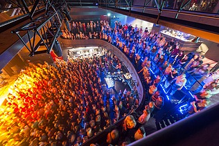 Concert hall of the multifunctional building filled with people and subdued lighting