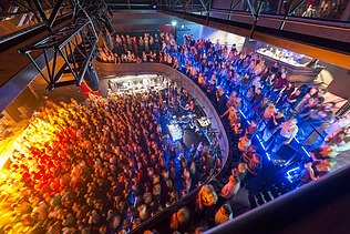 Concert hall of the multifunctional building filled with people and subdued lighting