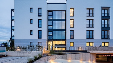 Ansicht der Wohnanlage HUGO Komfort in Bayreuth mit Zufahrt zur Tiefgarage und Haupteingang