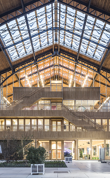 Foto des Hallenraumes des Gare Maritime Brüssel. Riesiger, offener Hallenraum mit Holzdachkonstruktion.